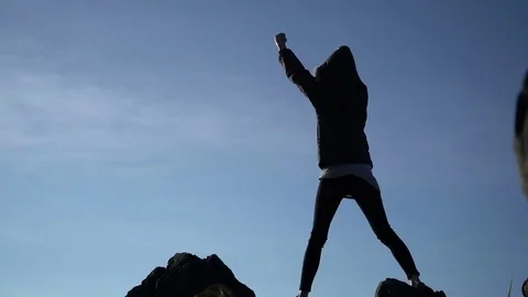Woman raising arms victoriously after climbing the mountain Stock Footage
