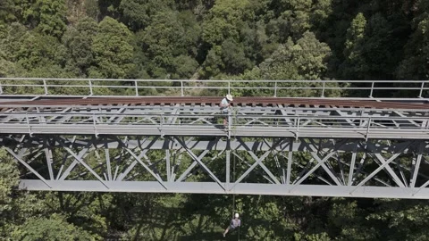 Woman rapelling off a train bridge Stock Footage 288739302