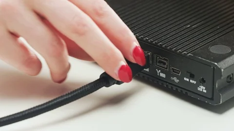 Woman Re-plugging Black Cable to a Device Stock Footage 69789953