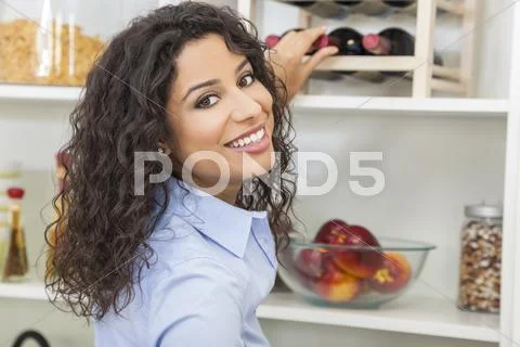 Woman Reaching for Bottle of Red Wine on Rack Stock Photos