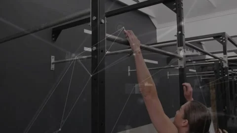 Woman reaching pull-up bar, adjusting grip then pulling chin above bar for Video stock 330621696
