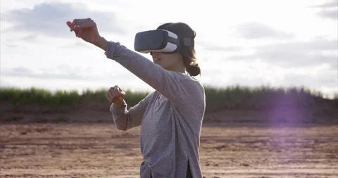 Woman reaching for something in virtual space as she wears VR goggles - side  Stock Footage