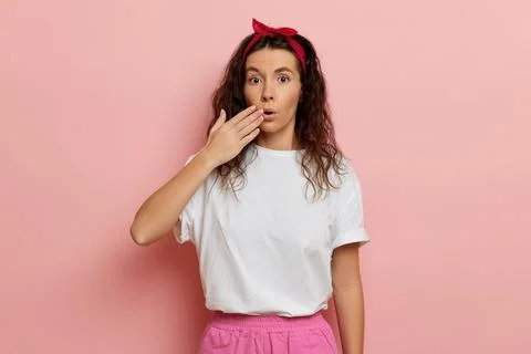 Woman reaction on sudden news, isolated over pink wall Stock Photos