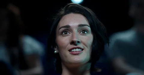 A woman reacts impressed to a moment in a film while at the cinema Stock Footage