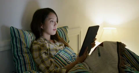 Woman read on tablet computer and lying on bed at night Video stock 188866639