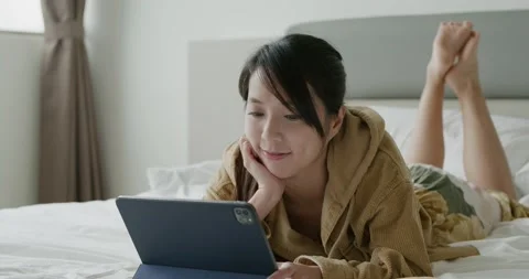 Woman read on tablet computer and lying on bed Video stock 194850893