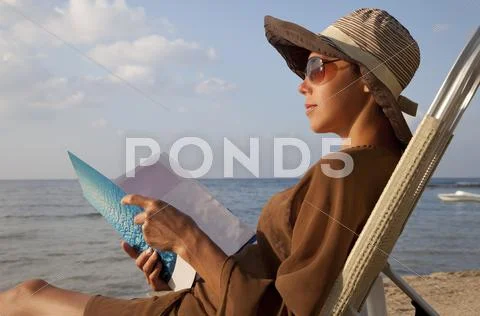 Woman reading book at beach Stock Photos