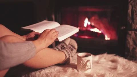 Woman Reading a Book by the Cozy Fireplace. 4K Stabilized shot. Stock Footage