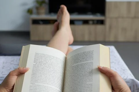 Woman reading a book relaxed on the sofa Stock Photos
