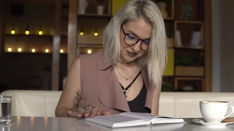 Woman reading book while drinking coffee Stock Footage 83920868
