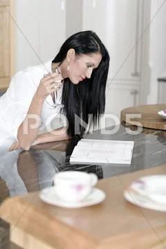 Woman reading a cookery book Stock Photos