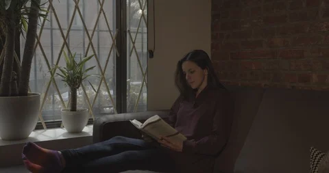Woman reading on couch Stock Footage 129198260