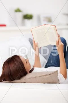 Woman reading on a couch Stock Photos