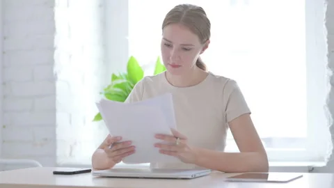 Woman Reading Documents while Sitting in Office Stock Footage 205000832