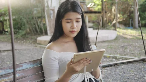 A woman reading e-book or tablet in the park Stock Footage 108455210