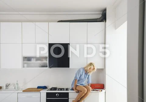 Woman Reading On Kitchen Counter