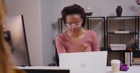 Woman reading laptop screen, tapping pen, pointing at monitor, writing notes for Stock Footage 342284544