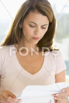 Woman reading letter and frowning Stock Photos
