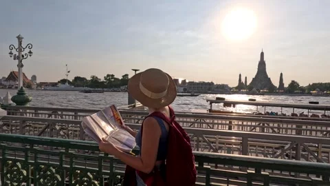 Woman Reading Map by Riverside Temple at Sunset Stock Footage 325164329