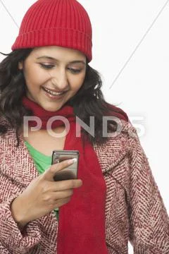 Woman reading a message on a mobile phone and smiling Stock Photos