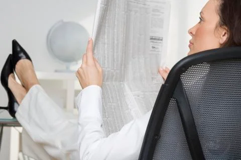 Woman reading newspaper business page Stock Photos