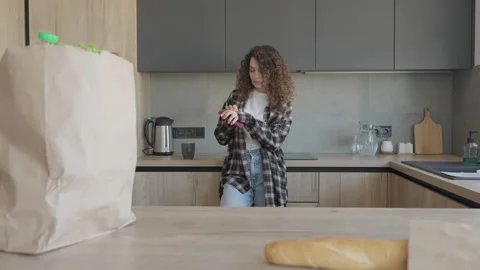 Woman Reading Phone Message While Standing In Cozy Modern Kitchen Stock Footage 311278577