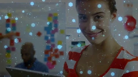 Woman reading tech data on tablet looking up smiling while blue hexagons Stock Footage 333278683