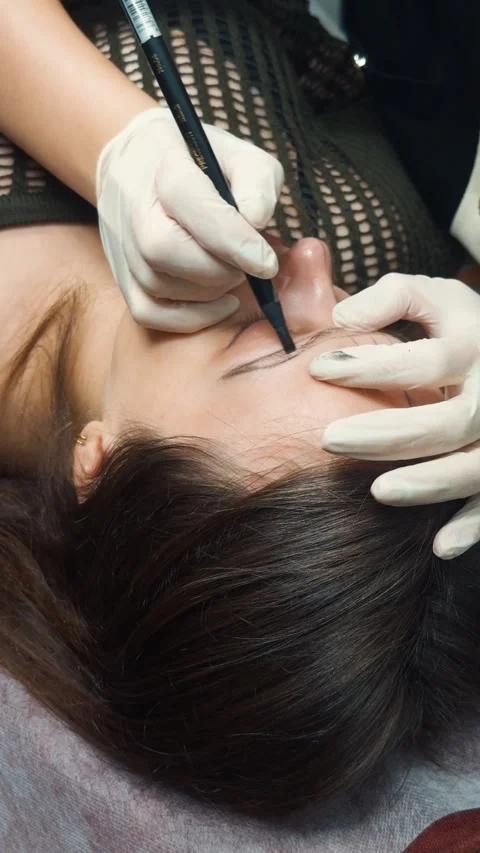 Woman receiving eyebrow microblading application procedure in beauty salon, Video stock 332058289