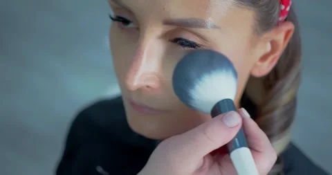 Woman Receiving Makeup in Bright Studio Setting 스톡 동영상 323494553