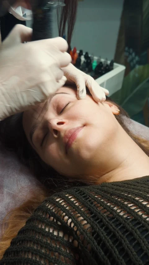 Woman receiving microblading permanent makeup for her eyebrows in a beauty salon Video stock 331574394