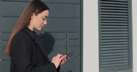 Woman receiving parcel from post terminal machine using smartphone outdoors. Stock Footage 297762995