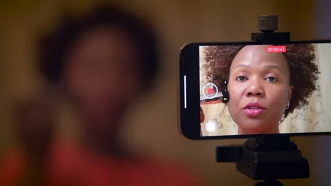 A woman is recording a makeup tutorial video in her home for her online 動画素材 276392506