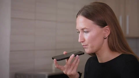 Woman Recording Voice Message Using Smartphone In Kitchen 库存影片 295844709