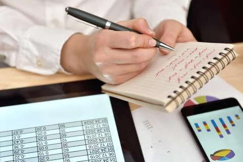Woman records data in notebook Stock Photos