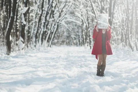 Woman with a red coat is hiding her face, snowy forest in winter Stock Photos