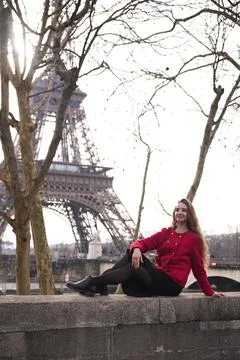 Woman in red coat posing by Eiffel Tower Stock Photos