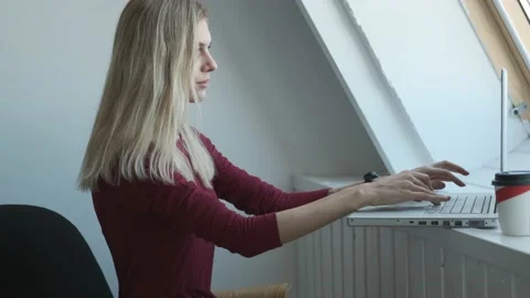 Woman in red dress working at laptop at home Stock Footage