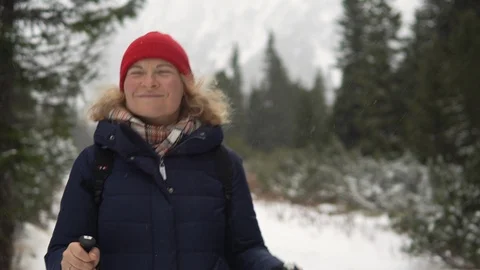 Woman in red hat walking through the snowy winter forest in High Tatra mountains Stock Footage 124949060