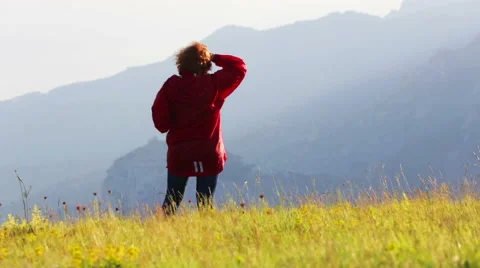 Woman in red jacket standing on the side of a mountain in autumn day Stock Footage 63662330