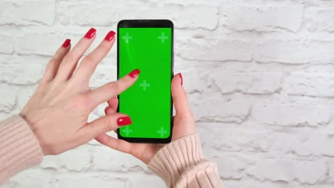 Woman with red nails using green screen chroma key phone in vertical position Stock Footage 264896792