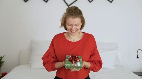 Woman with red sweater holding present in authentic room. Stock Footage 102654853