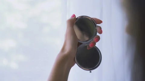 Woman reflection in a pocket mirror, applying powder makeup Video stock 137125144