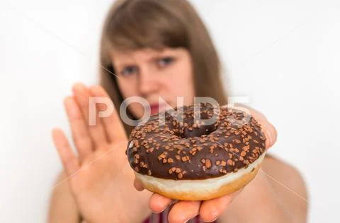 Woman refuses to eat donut - dieting concept Stock Photos