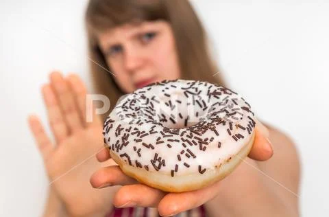 Woman refuses to eat donut - dieting concept Stock Photos