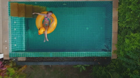 Woman relaxing on duck float in thailand pool Stock Footage 278163353