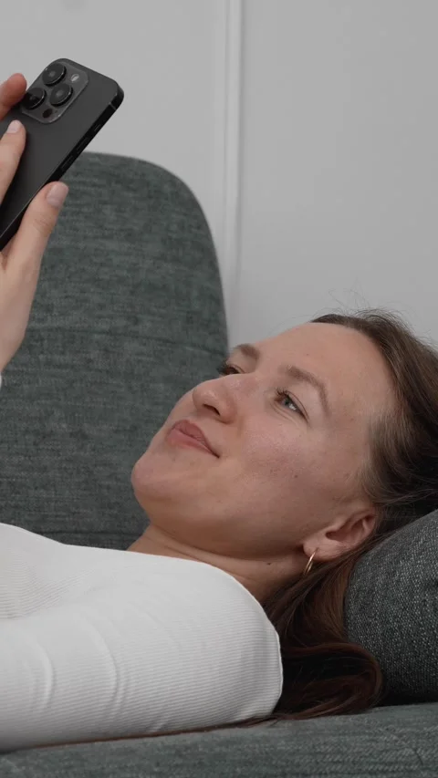 Woman relaxing on sofa using smartphone Vídeo Stock 308258963