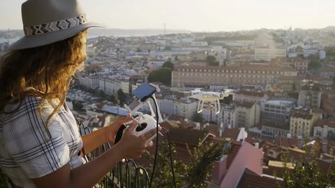 Woman with remote control using drone flying above roofs Video stock 104680484