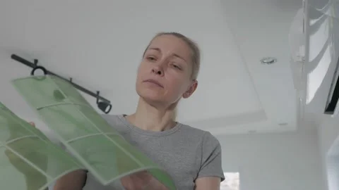 The woman removed the air filter from the split system, examines it before Video stock 146095712