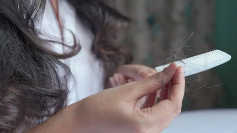 Woman removes large strands of fallen hair from the comb Stock Footage 242568705