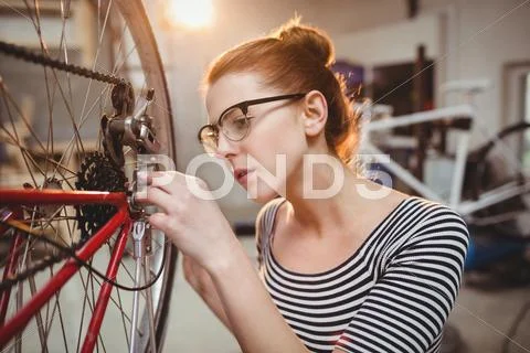 Woman repairing a bicycle wheel Stock Photos